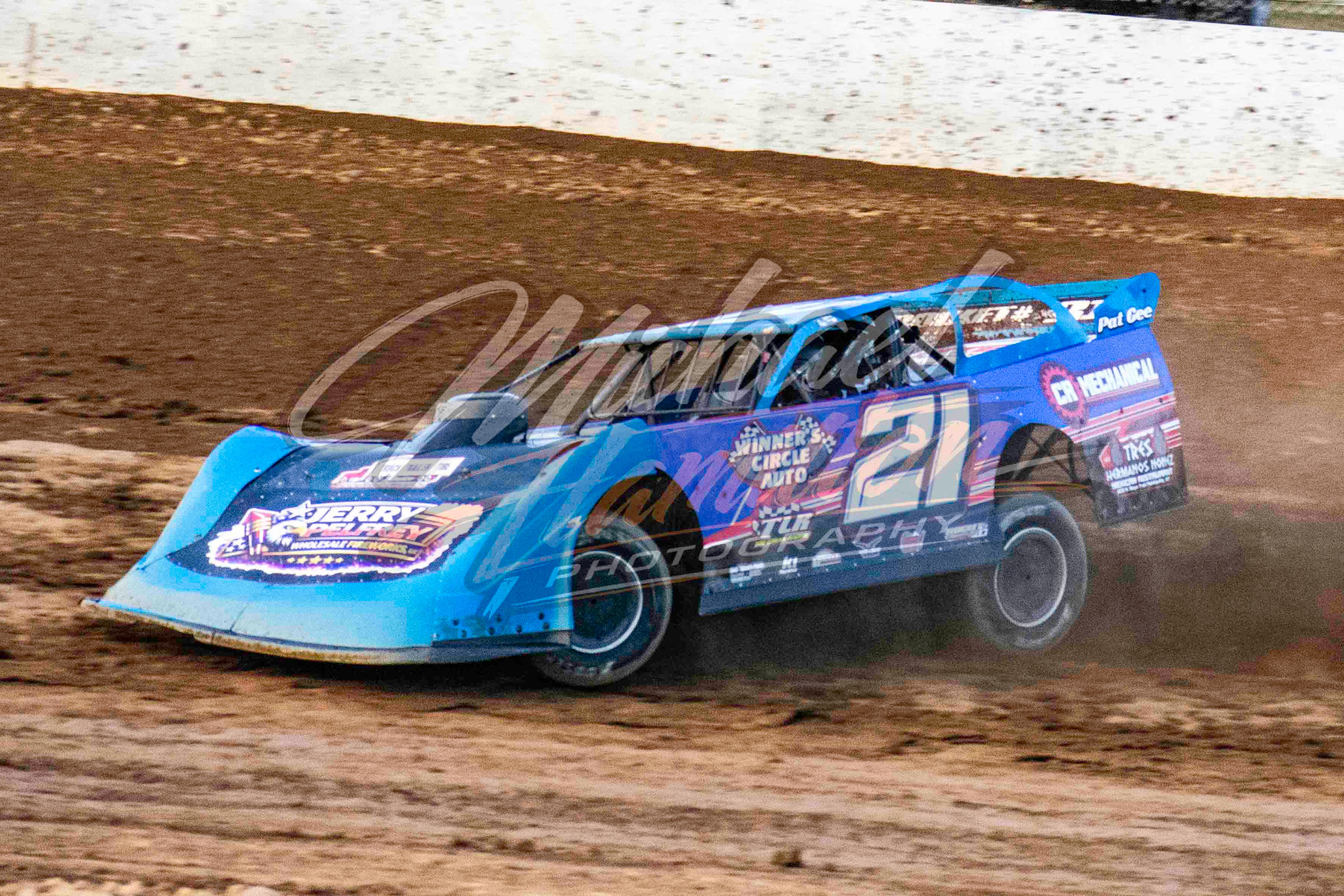 Blue number 21 dirt late model kicking up dust
