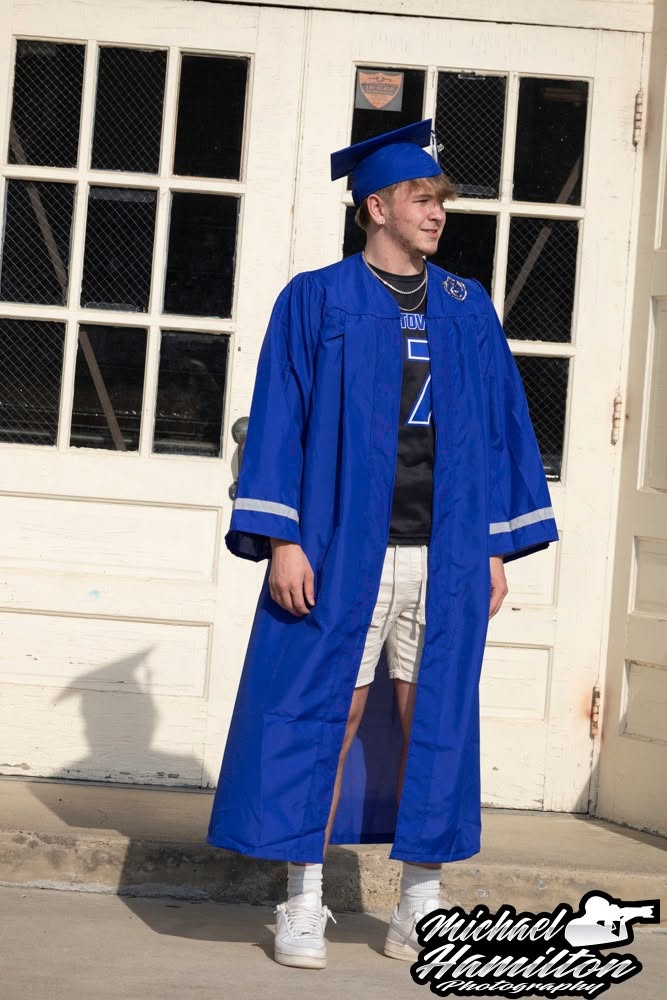 Senior portrait in a blue graduation cap and gown